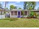 Charming home featuring a well-manicured lawn and a lovely purple front door at 2909 60Th N Ave, St Petersburg, FL 33714