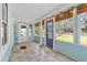 Enclosed front porch featuring tile floors, string lights, and colorful, stained glass door at 2909 60Th N Ave, St Petersburg, FL 33714