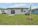Backyard featuring a well-maintained lawn, concrete patio, and gray exterior at 3590 Moscato Dr, Brooksville, FL 34602