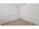 Cozy bedroom with neutral carpet, two white doors, and fresh, light-filled space at 3590 Moscato Dr, Brooksville, FL 34602