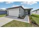 Exterior shot of a single-Gathering home with a two-car garage, front walkway, and landscaped flower beds at 3590 Moscato Dr, Brooksville, FL 34602