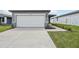 Exterior shot of a home's garage with a white garage door, concrete driveway, and landscaped front yard at 3590 Moscato Dr, Brooksville, FL 34602