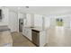 Kitchen island with stainless steel dishwasher, white cabinets, granite countertops, and a view of the living room at 3590 Moscato Dr, Brooksville, FL 34602