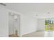 Bright living room with neutral tile flooring, light walls, recessed lighting, and sliding glass doors to the outside at 3590 Moscato Dr, Brooksville, FL 34602