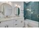Modern bathroom features double vanity, framed mirrors, beautiful blue tiled shower/tub combo and new fixtures at 4021 Ohio Ave, Tampa, FL 33616