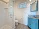 Bathroom with walk-in shower, blue vanity, and mosaic tile at 404 Hillsborough St, Palm Harbor, FL 34683