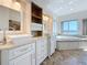 Bathroom featuring double vanities, and a large soaking tub with waterfront views at 404 Hillsborough St, Palm Harbor, FL 34683
