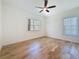 Bright bedroom features wood floors, a ceiling fan, and a window overlooking the backyard at 404 Hillsborough St, Palm Harbor, FL 34683