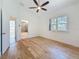 Bedroom with wood flooring, ceiling fan, and ensuite bathroom; door open to view at 404 Hillsborough St, Palm Harbor, FL 34683