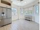Light-filled breakfast nook with stainless steel refrigerator, desk/console, and many windows with views at 404 Hillsborough St, Palm Harbor, FL 34683
