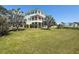 Three-story home with balconies, lush lawn, and mature palm trees at 404 Hillsborough St, Palm Harbor, FL 34683