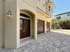 Elegant home showcasing a three-car garage, brick-paved driveway, and sophisticated exterior at 404 Hillsborough St, Palm Harbor, FL 34683