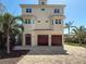 Charming three-story home with a brick driveway, mature landscaping, and a welcoming facade at 404 Hillsborough St, Palm Harbor, FL 34683