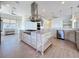 Bright kitchen features an island with a cooktop, stainless appliances, pendant lighting, and wood-look flooring at 404 Hillsborough St, Palm Harbor, FL 34683