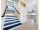 Staircase with black and white risers, hardwood floors and view of kitchen at 404 Hillsborough St, Palm Harbor, FL 34683
