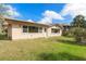 A backyard featuring lush green grass, mature landscaping and a single-story house at 4120 Marine Pkwy, New Port Richey, FL 34652