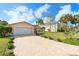 Charming single-story home with a brick driveway and a well-manicured lawn surrounded by lovely palm trees at 4120 Marine Pkwy, New Port Richey, FL 34652