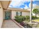 Inviting front entrance with brick walkway, lush landscaping, and a charming set of glass double doors at 4120 Marine Pkwy, New Port Richey, FL 34652