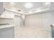 Bright kitchen featuring white cabinets, tiled floors, and modern light fixture at 4120 Marine Pkwy, New Port Richey, FL 34652