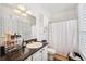 Bathroom featuring white cabinets, dark countertops, and a shower with a curtain at 501 Knights Run Ave # 5101, Tampa, FL 33602