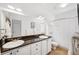Bright bathroom featuring double sinks, white cabinets, and a large mirror at 501 Knights Run Ave # 5101, Tampa, FL 33602