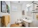 Well-lit half bathroom features a pedestal sink, tile floors, and charming decor at 501 Knights Run Ave # 5101, Tampa, FL 33602