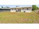 Expansive backyard showcasing a well-maintained lawn, a small patio, and perimeter fencing at 6556 S West Shore Cir, Tampa, FL 33616