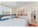 Comfortable bedroom featuring a queen bed with a grey headboard, soft lighting, and wall art at 6556 S West Shore Cir, Tampa, FL 33616