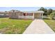 Well-kept single-Gathering home featuring a tidy lawn and a driveway leading to the carport at 6556 S West Shore Cir, Tampa, FL 33616