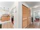 Hallway featuring a set of louvered closet doors and open view to kitchen and room with chair at 6556 S West Shore Cir, Tampa, FL 33616