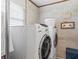 Laundry area features a white washer and dryer against a concrete wall at 6556 S West Shore Cir, Tampa, FL 33616