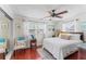 Sunlit main bedroom with a ceiling fan, hardwood floors and serene decor at 6556 S West Shore Cir, Tampa, FL 33616