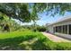 Large backyard with green grass, trees, and patio along the rear of the house at 719 Straw Lake Dr, Brandon, FL 33510