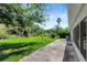 Lush green backyard featuring a concrete patio and a variety of trees at 719 Straw Lake Dr, Brandon, FL 33510