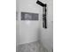 Modern bathroom featuring a tiled shower with a sleek shower panel and mosaic tile floor at 719 Straw Lake Dr, Brandon, FL 33510