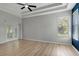 Bright bedroom with light wood floors, ceiling fan, tray ceiling, and natural light from a window at 719 Straw Lake Dr, Brandon, FL 33510