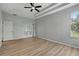 Bright bedroom with light wood floors, ceiling fan, tray ceiling, and french doors leading to the outdoors at 719 Straw Lake Dr, Brandon, FL 33510