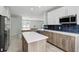 Open concept kitchen with a large island, stainless steel appliances, and seamless flow into the dining area at 719 Straw Lake Dr, Brandon, FL 33510
