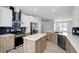 Bright kitchen featuring white cabinets, stainless steel appliances, and center island with quartz countertops at 719 Straw Lake Dr, Brandon, FL 33510