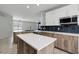 Open concept kitchen featuring modern appliances, island with quartz countertops, and views to the living room at 719 Straw Lake Dr, Brandon, FL 33510