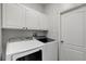 Functional laundry room featuring modern washer and dryer units with overhead storage at 719 Straw Lake Dr, Brandon, FL 33510