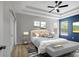 Spacious main bedroom showcasing a tray ceiling, ceiling fan, wood floors, and ensuite bath access at 719 Straw Lake Dr, Brandon, FL 33510