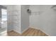 Spacious walk-in closet with white wire shelving and wood flooring next to bathroom at 719 Straw Lake Dr, Brandon, FL 33510
