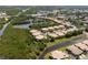 Aerial view of residential condos nestled along a waterway with mature trees and landscaping at 7657 Caponata Blvd, Seminole, FL 33777