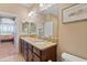 Bathroom featuring double sinks with granite counters and dark wood cabinetry at 7657 Caponata Blvd, Seminole, FL 33777