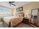 Bright bedroom featuring tropical bedding, plantation shutters, and a ceiling fan at 7657 Caponata Blvd, Seminole, FL 33777