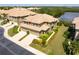 Two-story condo with attached two-car garage, manicured landscaping, and ample parking spaces at 7657 Caponata Blvd, Seminole, FL 33777
