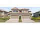 Charming two-story townhome featuring a neutral color palette, large garage doors, and well-maintained landscaping at 7657 Caponata Blvd, Seminole, FL 33777