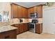 Kitchen boasts stainless steel appliances, granite counters, tiled backsplash, and ample wood cabinet storage at 7657 Caponata Blvd, Seminole, FL 33777