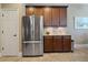 Modern kitchen features a stainless steel refrigerator, wooden cabinets, and granite countertops at 7657 Caponata Blvd, Seminole, FL 33777